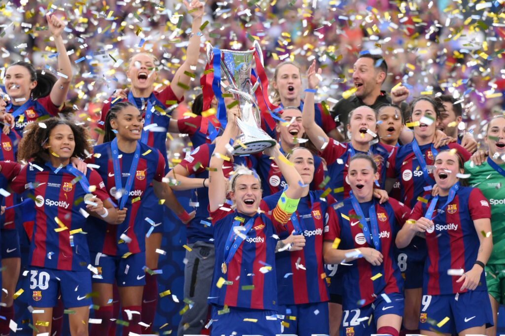 FM26 Women's Football: Barcelona Femení players lifting the UEFA Women’s Champions League trophy.